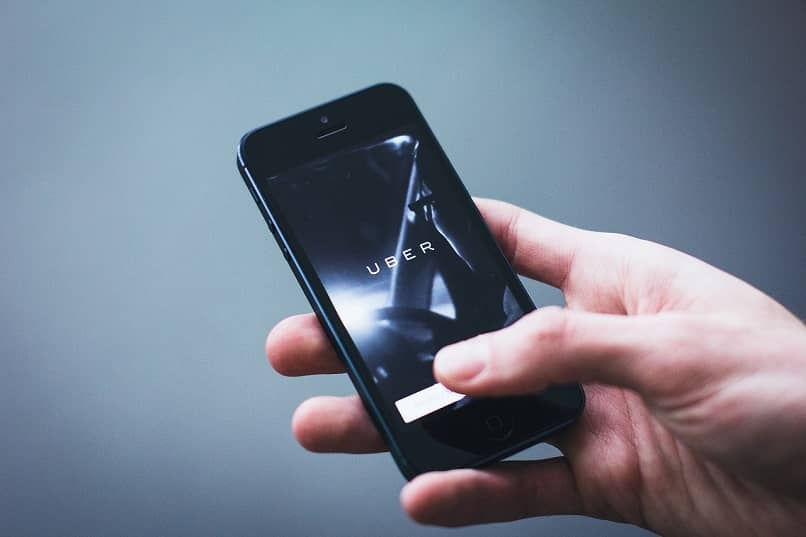 mano sosteniendo un telefono con la aplicacion de uber